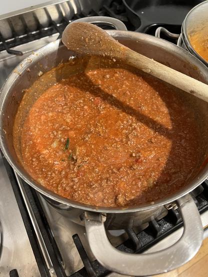Bolognese simmering, sprig of rosemary just visible 