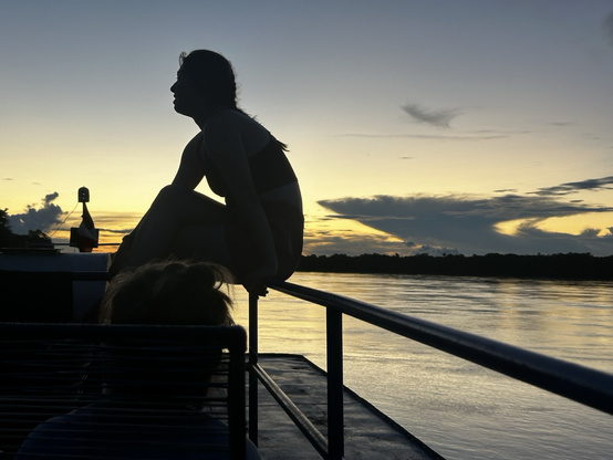 Sunset on the Amazon with a female silhouette in shadow