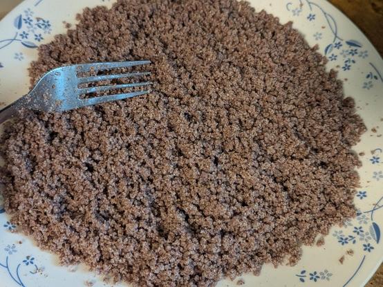 Coarse red rice (looks quite brown) powder mixed with a bit of salt and water and mixed and spread out on a plate to avoid lumps and clumps