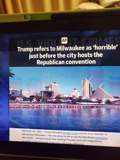 Color photo of the Milwaukee skyline bright blue, a body of water in foreground. Headline and caption are long but in essence say that Trump is trash-talking Milwaukee ahead of convention
