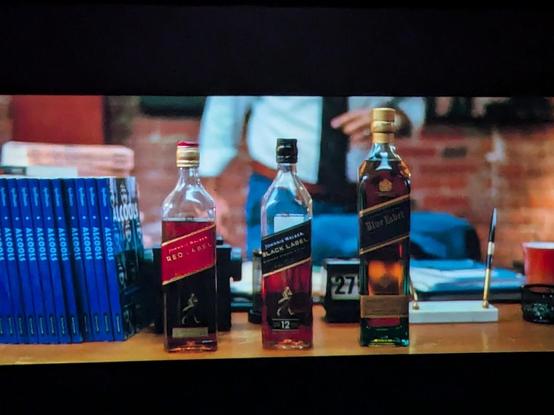 Still from the movie with 3 bottles of Johnnie Walker whiskey on a table
