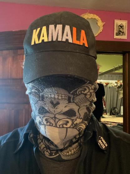 Person wearing a Kamala cap and a face covering.