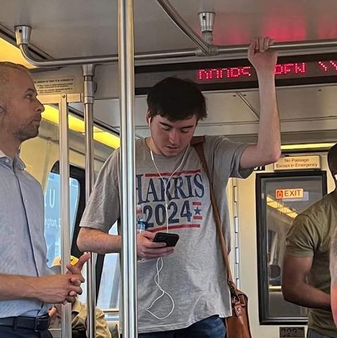 Photo of a young man in a T-shirt reads Harris 2024