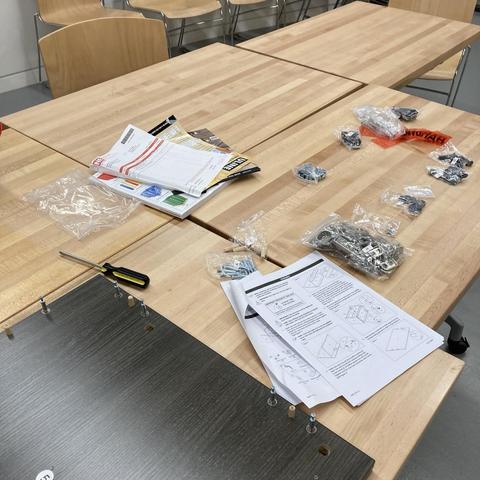A table covered in tools, parts, and assembly instructions