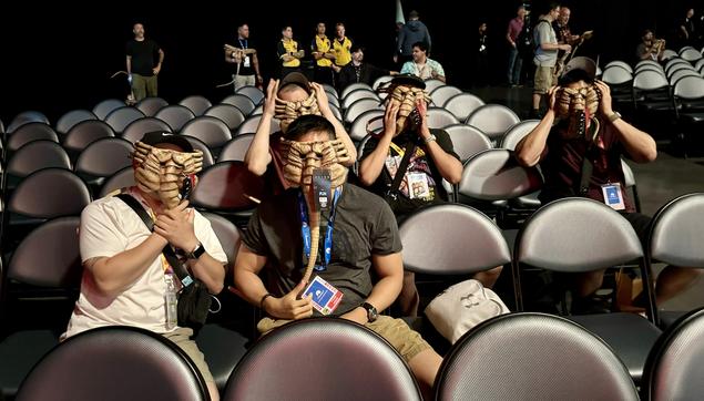 Five guys in the audience for the an Alien: Romulus panel at Comic-Con. They each have face higher masks on.