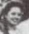 very blurry photo, cropped from a group shot, of Adelaida Abarca Izquierdo as a young woman in prison. Hair in plaits, smiling 