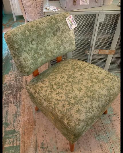An avocado green upholstery with a funky 1960s sunburst satin pattern on a sleek slipper-style chair