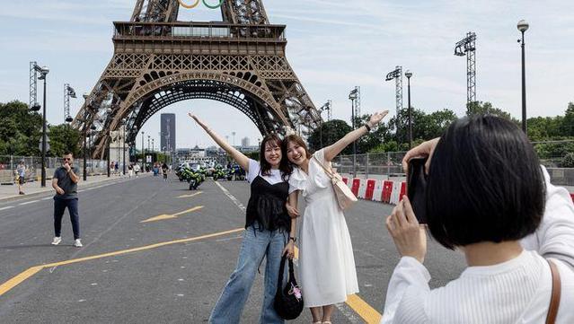 Dues turistes es fan una foto al davant de la torre Eiffel, decorada amb les anelles olímpiques (Reuters/Marko Djurica)