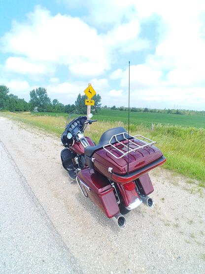 Our 2017 Harley-Davidson Ultra Limited stopped on the side of the road near the Lake Huron Shoreline in Southern Ontario. The motorcycle is near road signage that warns of crossing deer, turtles, and snakes. 