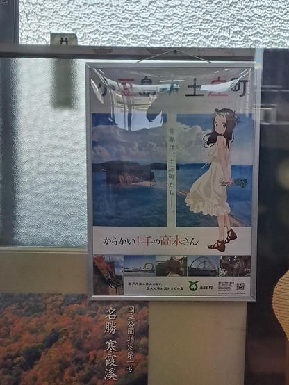 Póster de Takagi-san en la oficina de venta de tickets del ferry.