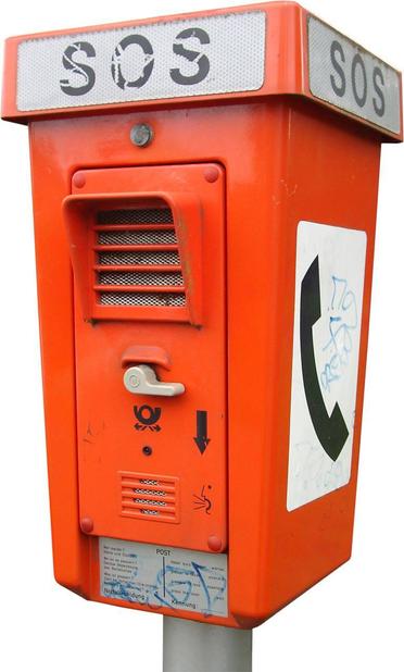 Das Bild zeigt einen roten Telefonkasten mit der Aufschrift „SOS“
