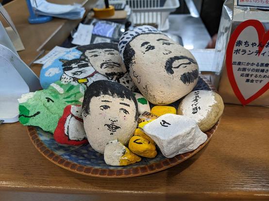 A small tray on a counter with small and large pebbles painted as faces

Isahaya #Kyushu #Japan Nov 2023