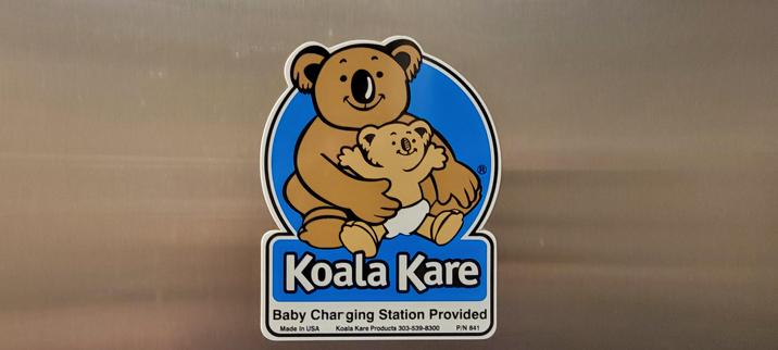 A Koala Kare sticker in a public restroom. It should say this is a Baby Changing Station, but one of the letters n is worn so it says Baby Charging Station.