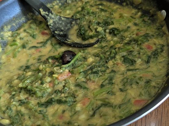 Chopped greens laden yellow toor daal in a pan