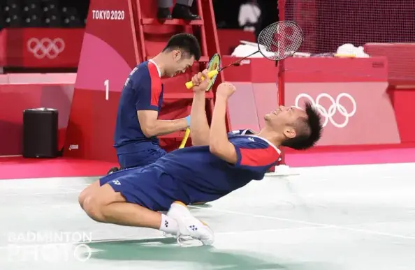 Taiwanese badminton players Lee Yang 李洋 and Wang Chi-lin 王齊麟 when they clinched the victory at the Badminton Men's Double final at the Tokyo 2020 Summer Olympics. Lee bent over backwards while Wang crouched forward.