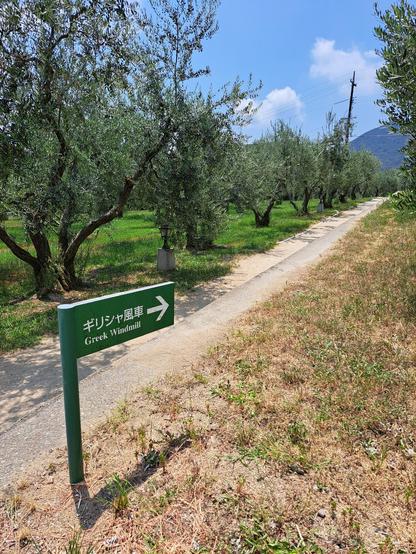 Camino que lleva al molino griego, con un cartel de dirección.

Olive Park, Shōdoshima, Japón.