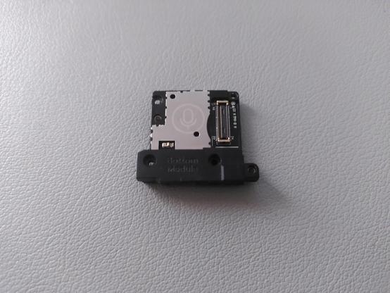 Foto del módulo viejo. En una parte metálica se ve un icono representando un micrófono, a la derecha está el conector a la placa y abajo se intuye la salida USB-C.