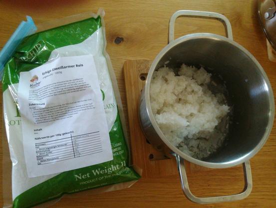 A pot with cooked Echigo low-protein rice and the package on the side