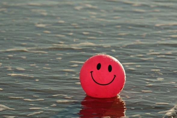 Pink ball with a smiley face floating on water.

Some may think 
