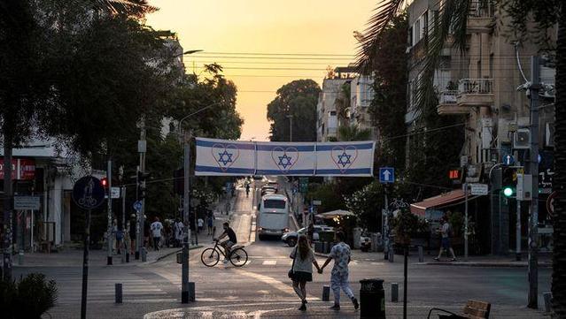 Gent passejant per Tel-Aviv sota diverses banderes israelianes (Reuters/Eloisa Lopez)