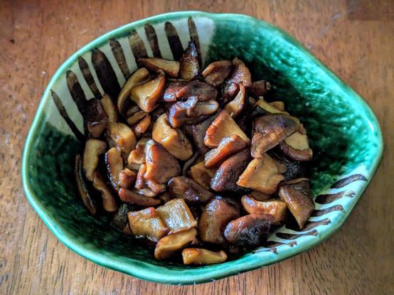 Sauteed shiitake mushrooms caps (quarters) in a small bowl