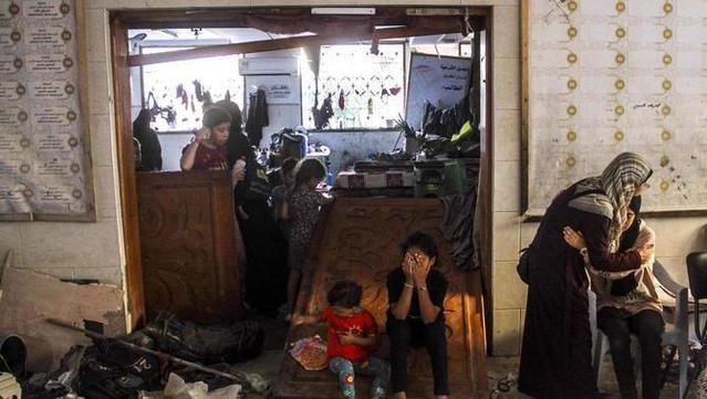 Uns palestins ploren després de l'atac israelià a l'escola del barri de Daraj Tuffah de Gaza (EFE/EPA/Mahmoud Zaki)