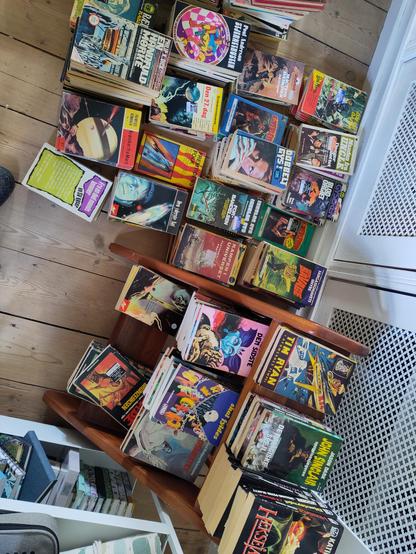 Et gulv fyldt med bøger stablet i serier, som SV science fiction, Rædselskabinettet, Manden fra UNCLE, Doc Savage og lignende.