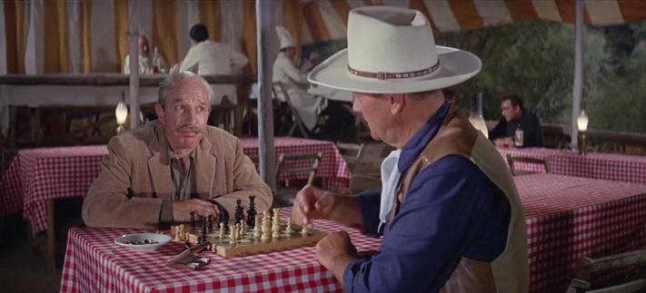 In a scene from Circus World, Lloyd Nolan and John Wayne play chess.