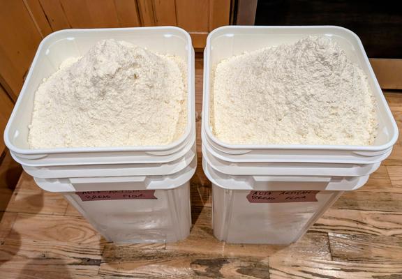 Two plastic tubs filled with bread flour.