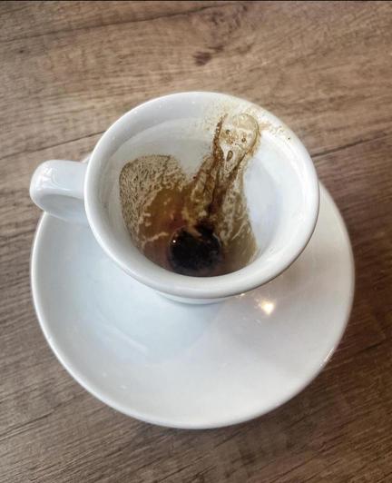 Photography. Color photo of an empty white coffee cup with coffee grounds sticking up to the rim. A screaming face from Edvard Munch's painting of the same name can be seen in the coffee grounds. 
Info: Subtle photographic art by Alessandro Malossi. He is a contemporary Italian artist known for his digital artworks and his collaborations with the fashion industry. On Instagram, he talks about his life with his often satirical photo experiments.