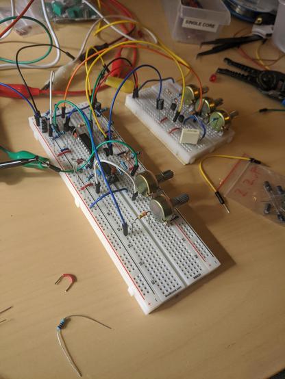 2 breadboards holding a mess of resistors, transistors, potentiometers and wires.