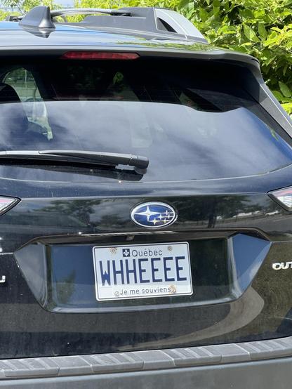 Rear view of a black Subaru Outback with a Quebec license plate that reads 