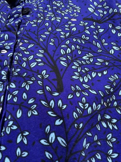 Kitenge cloth in sapphire blue with a black branching design that has tiny turquoise leaves all over it.