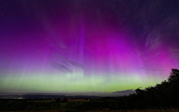 Brilliant aurora borealis display with vibrant purple, blue, red and green rays