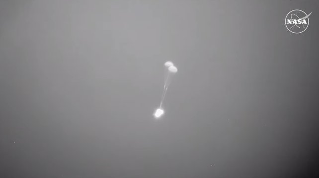 Infrared view of Starliner descending under two drogue parachutes