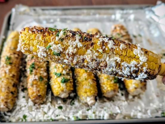 Steamed 10 min then grilled corn smeared with cotija cheese and cayenne and lime zest and a bit of chopped cilantro, all after a thin application of mayonnaise (Hellmans + Kewpie mix)