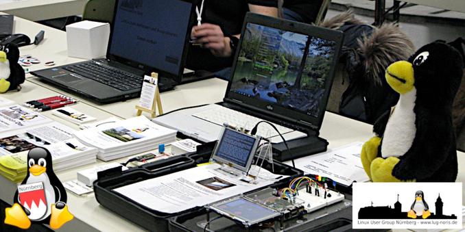 Foto: Unsere Tische auf der Hack&Make 2023. Dort u.a. abgelegt unser Infomaterial sowie zwei Linux-Rechnern und unsere kleinen Hardware-Projekte zum Anfassen. In der rechten Ecke wacht unser Tux damit alles korrekt abläuft ;-) Wir freuen uns schon heute wieder auf zahlreiche Besucher an unserem Stand!