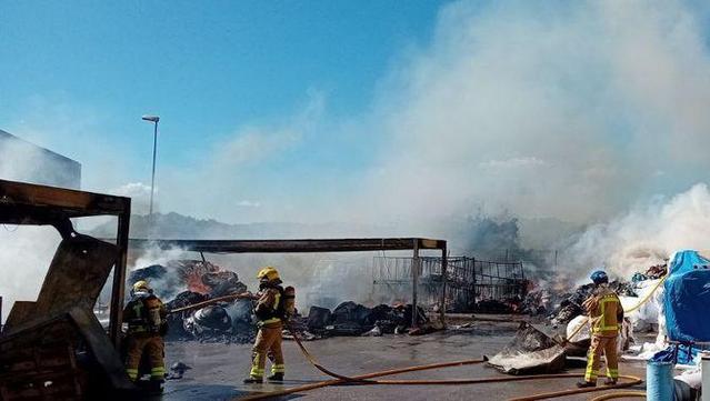 Onze dotacions dels bombers treballen en l'extinció d'un incendi al pati d'una indústria a la Roca del Vallès