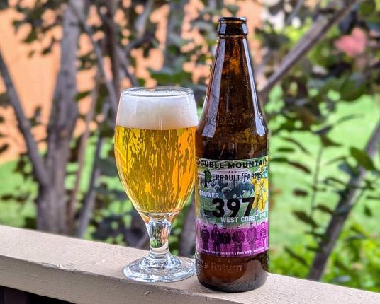 A bottle of Grower 397 West Coast IPA from Double Mountain Brewery of Hood River, Oregon, poured into a goblet-style glass.