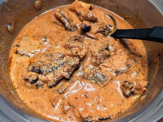 A pot of tandoori chicken pieces napped in a thick gingery tomato and bit of cream sauce/gravy