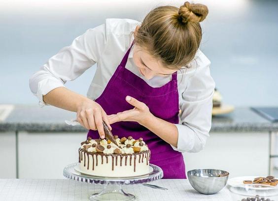 Une personne décore un gâteau