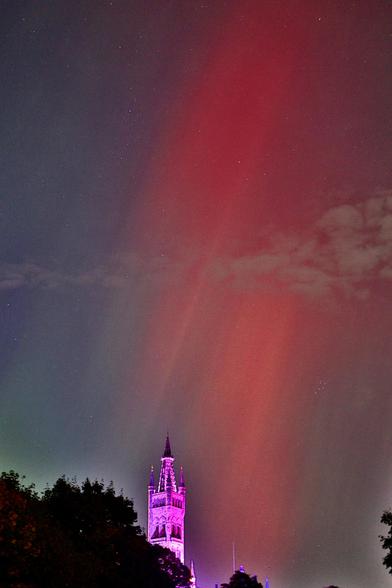 A red aurora above the tower of the university of Glasgow