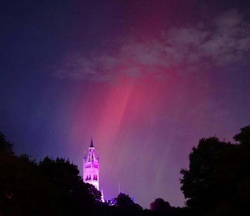 A red aurora above the tower of the university of Glasgow