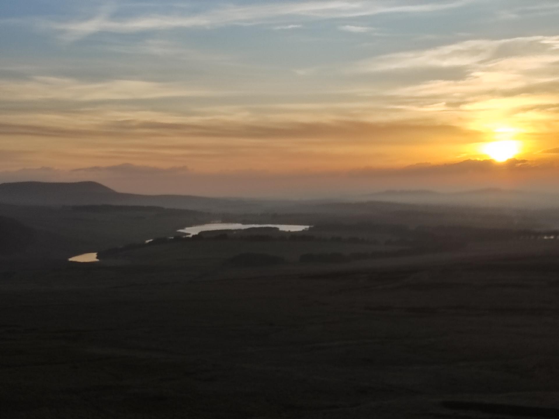 Sunset with hills and reservoir in foreground