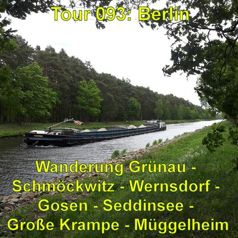 Ein langer Frachtschiff auf einem Kanal, umgeben von grünen Bäumen an den Ufern. Der Kanal ist ruhig und das Schiff scheint voll beladen zu sein, erkennbar an den sichtbaren Abdeckplanen über dem Frachtbereich. Die Ufer sind natürlich und wirken teilweise bewaldet. Es ist ein bewölkter Tag, und das Wasser reflektiert das diffuse Tageslicht.