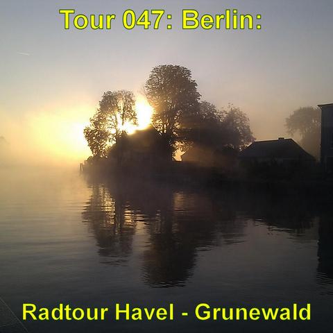 Ein stimmungsvoller Sonnenaufgang über der Havel, bei dem die Sonne hinter Bäumen und Gebäuden durch dichten Nebel hindurchscheint. Die Silhouetten der Bäume und Häuser spiegeln sich im ruhigen Wasser, während der Nebel die Landschaft in ein sanftes Licht taucht. Die Szene wirkt ruhig und mystisch, mit einer goldenen, warmen Atmosphäre, die die Umrisse der Natur und der Gebäude sanft verwischt.