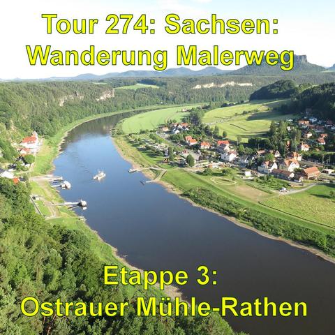 Ein Panoramablick auf die Elbe, der sich durch eine grüne Landschaft schlängelt, mit einem Dorf am Ufer. Im Hintergrund sind Berge zu sehen.
