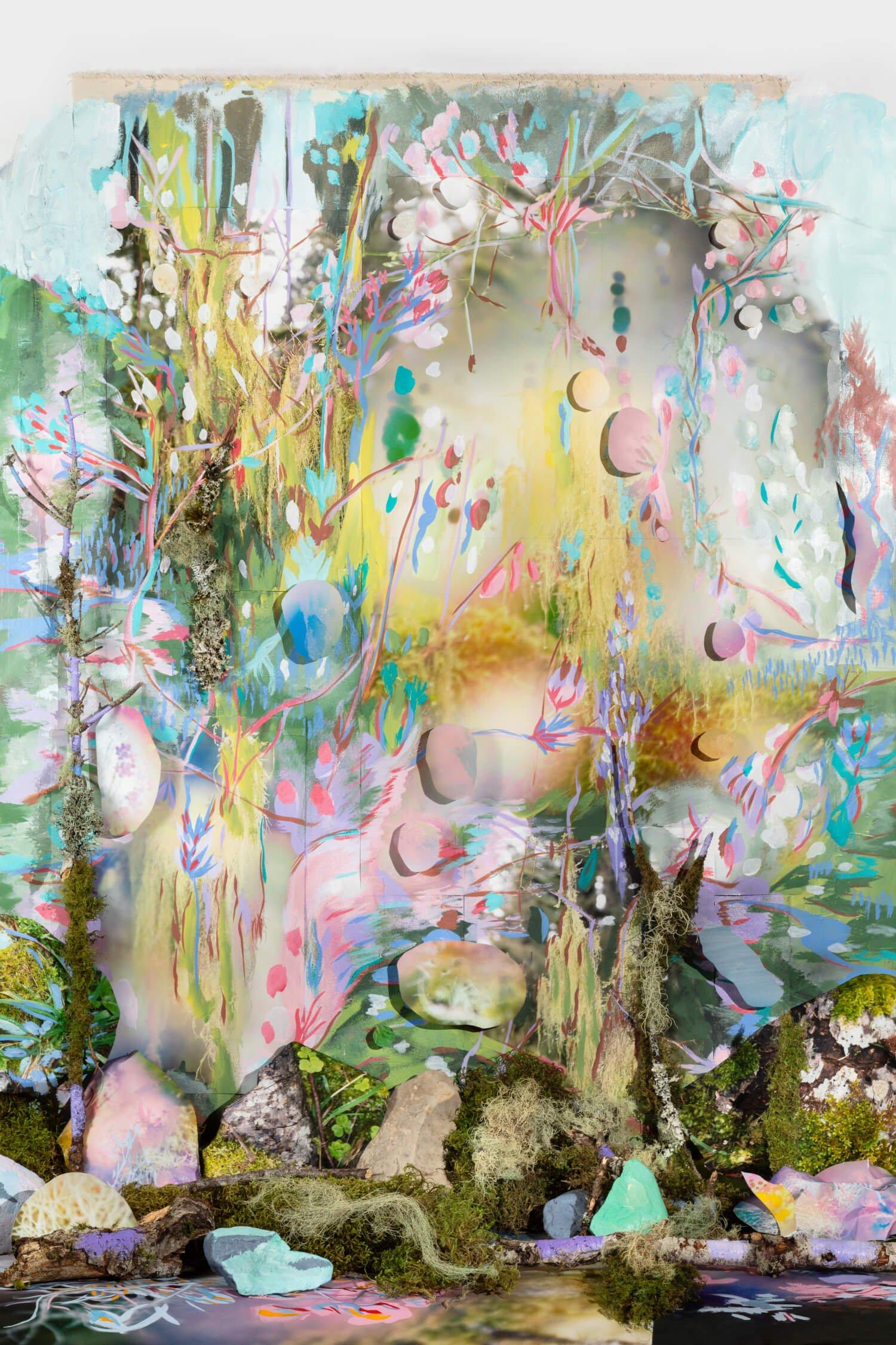Mixed media tableau with moss, twigs, and painted rocks set within a painted background with paper cutouts in pink, yellow, green, and blue.