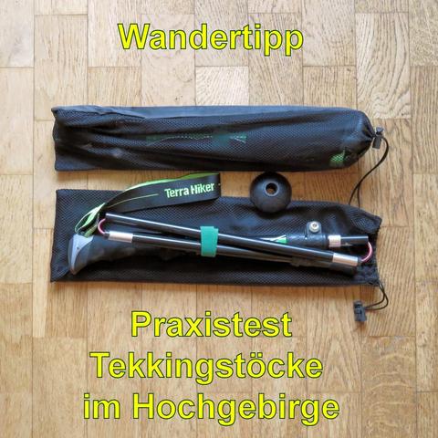 Ein Paar zusammenklappbare Trekkingstöcke der Marke Terra Hiker liegt in einem schwarzen Netzbeutel auf einem Holzboden. Ein Stock ist teilweise ausgepackt, während der andere noch im Beutel verstaut ist. Die Stöcke haben ergonomische Griffe und sind mit einem grünen Klettband fixiert. Eine schwarze Gummispitze zur Stabilisierung ist ebenfalls sichtbar. Die Trekkingstöcke sind leicht und kompakt, ideal für Wanderungen im Hochgebirge.
