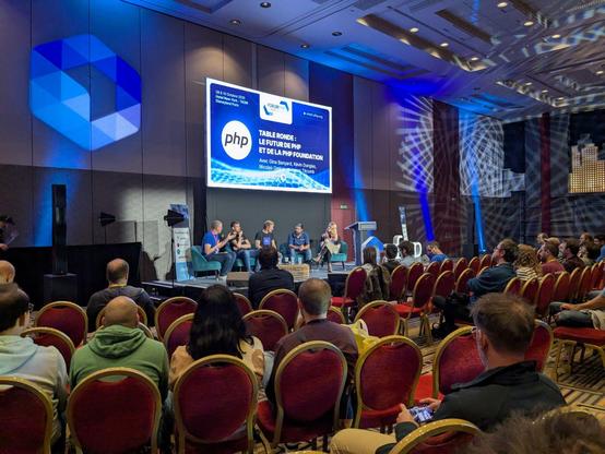 a round table discussion between experts about the future of PHP in front of a seated crowd